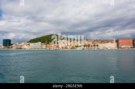 Die Uferpromenade der historischen Küstenstadt Split in Dalmatien, Kroatien. Der Marjan-Hügel befindet sich in der Mitte links, die Kirche und das Kloster des Heiligen Franziskus ganz rechts Stockfoto