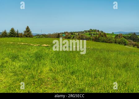 Wunderschöne sanfte Landschaft mit kleineren Hügeln, Wiesen und verstreuten Siedlungen über dem Dorf Oravska Lesna in der Slowakei im wunderschönen Frühling Stockfoto