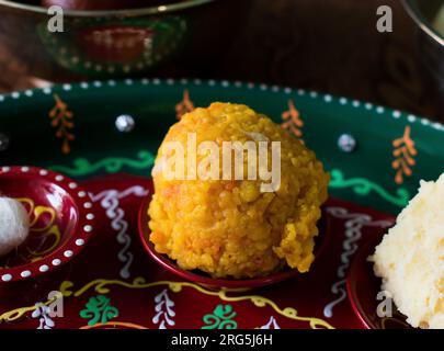 Bundi oder Boondi Laddu auf rotem Schild. Mithai oder prashad aus Besan und Desi Ghee auf Janmasthami, durga Puja oder Dussehra, Deepawali, Rakshabandhan Stockfoto