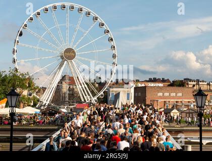 Menschenmenge auf der Wartka-Brücke über den Motlawa-Fluss am Amber Sky oder AmberSky-Riesenrad in der Altstadt von Danzig, Polen, Europa, EU Stockfoto