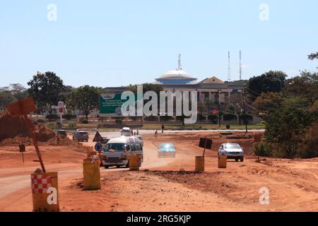 Das Parlament von Malawi ist von einer Baustelle aus zu sehen, auf der die Straße des Kenyatta Drive erweitert wird, um Staus auf der Straße in Lilongwe, Malawi, zu verringern. Stockfoto