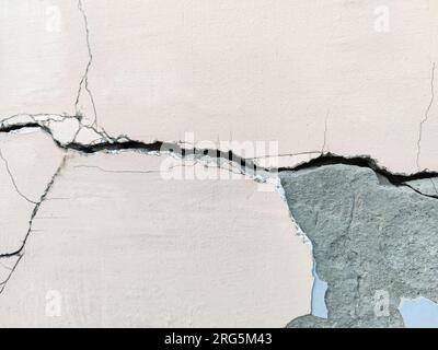 Großer langer gewundenen Riss an der Putzwand. Zerstörung an der Wand eines alten Gebäudes. Speicherplatz kopieren. Selektiver Fokus. Stockfoto