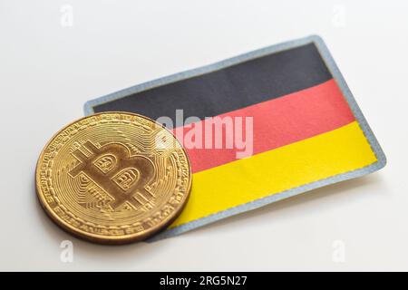 Eine Bitcoin auf einem deutschen Flaggenhintergrund. Das deutsche Gesetz erlaubt es institutionellen Fonds, am 2021. August in Kryptowährungen zu investieren Stockfoto