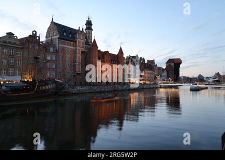 Abendlicher Blick auf das Motlawa-Ufer (Długie Pobrzeże) in Danzig, Polen, mit dem größten mittelalterlichen Hafenkran Europas, St. Marys Tor Stockfoto