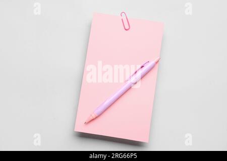 Papierbogen mit Clip und Stift auf grauem Hintergrund Stockfoto