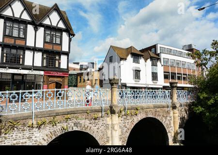 Eine Frau, die auf der Clattern Bridge steht, während sie den Hogsmill River in Kingston, Surrey, England, überquert Stockfoto