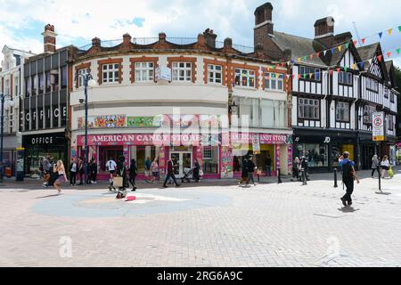 Ein junges Mädchen, das vor dem American Candy Store, Clarence Street, Kingston upon Thames, Kingston, Surrey, KT1, England, Großbritannien Stockfoto