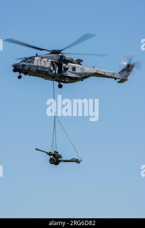 Ein Royal New Zealand Air Force NH90-TTH Hebegurt, der einen L119-Leichtgewehr 105mm Howitzer in Neuseeland lädt. Stockfoto