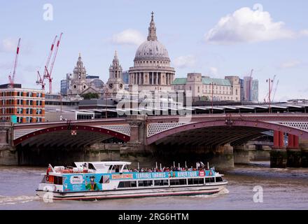 Ein Touristenboot auf der Themse fährt unter der Blackfriars Bridge durch und vor der St Paul's Cathedral London England Stockfoto
