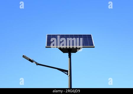 LED-Straßenbeleuchtung mit Solarmodul auf blauem Himmel, Nahaufnahme Stockfoto