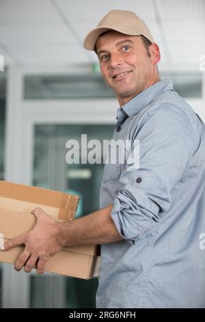 Der Zusteller liefert den Paketkarton an den Empfänger Stockfoto