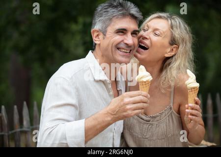Glückliches, reifes Paar, das ein Eis im Park isst Stockfoto