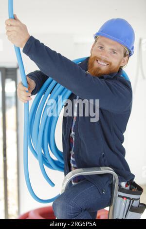 Der Elektriker ist zur Festsetzung einer elektrischen Wellrohr Stockfoto