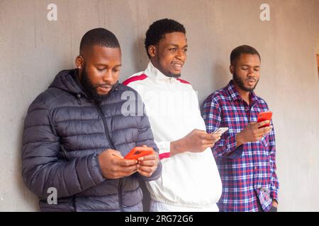 Gruppe multikultureller Freunde, die ihr Smartphone im Freien nutzen - Menschen, die von ihrem Smartphone abhängig sind - Technologiekonzept mit vernetzten Männern Stockfoto