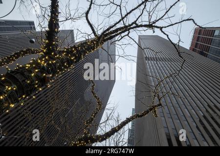 Blick von oben auf Wolkenkratzer und einige zu Weihnachten dekorierte Bäume im Bryant Park, New York, USA Stockfoto