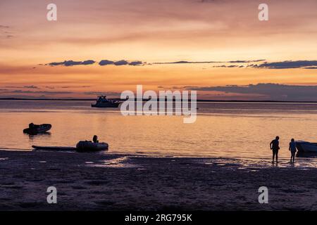 Fraser Island K'gari Sonnenuntergang über Kingfisher Bay mit Silhouetten von Booten und Menschenkügeln, Queensland, Australien Stockfoto