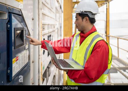 Der Inspektor Engineer benutzte einen Laptop und überwachte die Temperatur des Behälters. Stockfoto