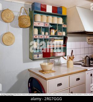 In den 1950er Jahren. Ein hübsches Farbbild der Details in einer Küche mit einem Regal mit Töpfen und Kochbüchern. Auf der Bank steht ein klassischer Blechbehälter mit Ridgways-Tee. Schweden 1958. Conard Stockfoto