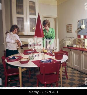 In den 1950er Jahren. Ein hübsches Farbbild von zwei Teenagern, die den Tisch mit Tellern, Gläsern und Besteck decken. Schweden 1958. Conard Ref BV42-5. Stockfoto