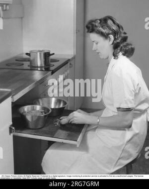 In den 1940er Jahren. Eine Frau sitzt am praktischen, ausziehbaren Schneidebrett und bereitet die Zutaten für ein Abendessen zu. Schweden 1944. Stockfoto
