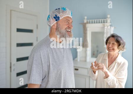 Glückliches, lachendes älteres Ehepaar, das im Badezimmer herumalbert Stockfoto