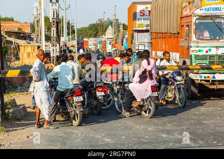 Fatehpur Sikri, Indien - 16. November 2011: Die Menschen warten am Bahnübergang in der Nähe von Fatehpur Sikri, Indien, um die Straße zu überqueren. Stockfoto