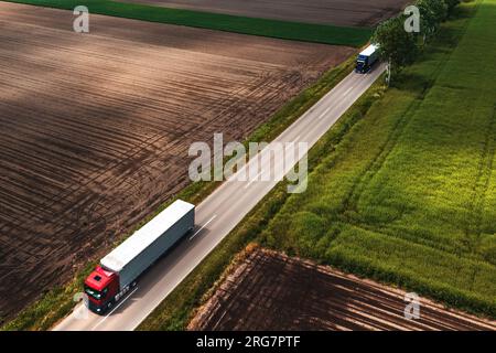 Zwei große Sattelschlepper auf Landstraßen aus Sicht der Drohne, Luftaufnahme von LKW und Logistikkonzept, Blick aus der Vogelperspektive Stockfoto