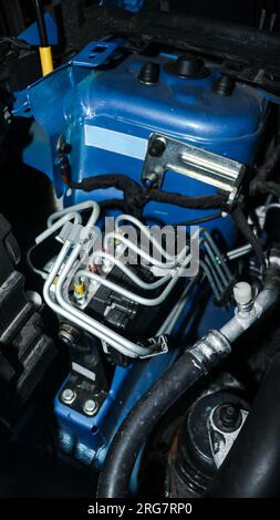 Ein elektronisches Steuergerät (ECU) mit Kabelverbindungen, das verschiedene Funktionen eines Fahrzeugs in der Nähe des Motors auf der Motorhaube steuert Stockfoto