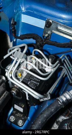 Ein elektronisches Steuergerät (ECU) mit Kabelverbindungen, das verschiedene Funktionen eines Fahrzeugs in der Nähe des Motors auf der Motorhaube steuert Stockfoto