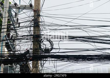 Störende Kabel der elektrischen Mast befestigt. Das Chaos der Kabel und Leitungen auf einem elektrischen Pol. Viele elektrische Kabel - Kabel und Telefonleitung auf wählen Stockfoto