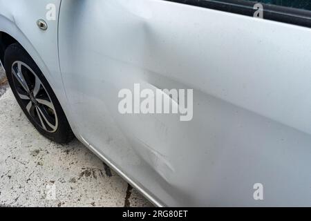 Große Delle mit Kratzern an der Autotür Stockfoto