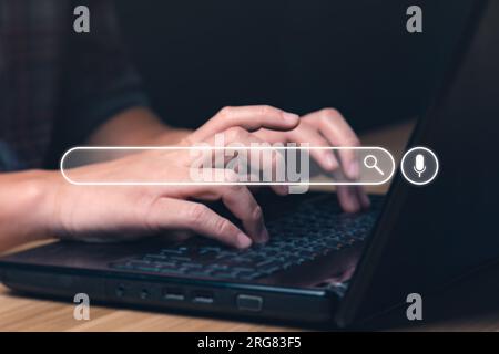 Geschäftsmann, der mit einem Laptop nach Informationen sucht, im Internet nach Konzeptinformationen surft. Ein Geschäftsmann, der ein Notebook für die Suche benutzt. Searchi Stockfoto