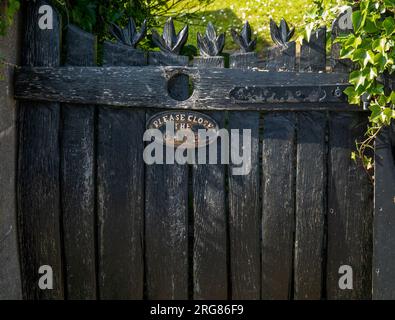 Altes hölzernes Tor mit bitte schließen Sie das Tor Stockfoto