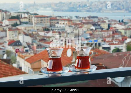 Zwei türkische Gläser in Form einer Tulpe gefüllt mit heißem schwarzem Tee mit Blick auf die Dächer des Uskudar-Viertels auf der asiatischen Seite von Istanbul, Türkei Stockfoto