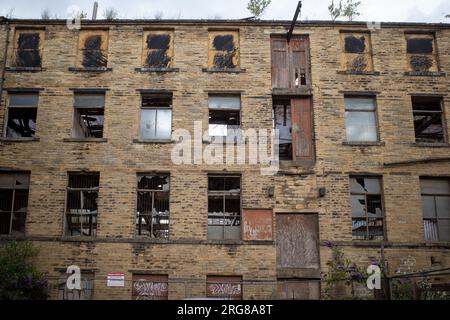 Fassade einer alten verfallenen Fabrik mit kaputten Fenstern in den Seitenstraßen von Bradford, Yorkshire, England, Großbritannien. 2023 Stockfoto