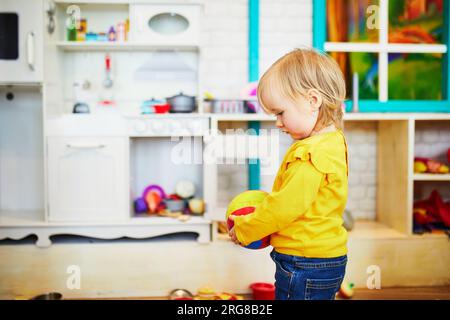 Ein bezauberndes Mädchen im Kindergarten, Kindergarten oder Vorschulalter. Das Kind hat Spaß im Café mit Spielzone. Indoor-Aktivitäten für kleine Kinder Stockfoto