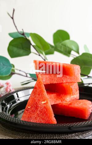 Frische Wassermelonenscheiben auf einer schwarzen Platte für ein lebendiges und appetitliches Display Stockfoto