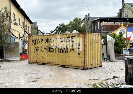 Kopenhagen, Dänemark. 08. Aug. 2023. Ein Container mit der Inschrift 'Stop udnyttelse af Christiania!' (Stoppt die Ausbeutung Christianiens) steht in der freien Stadt Kopenhagen Christiania. Eine Gruppe von Bewohnern Christianiens ist verärgert über die Präsenz krimineller Banden im alternativen Wohnungsbau und hat die Drogenstraße - bekannt als Pusher Street - blockiert, um gegen Banden und Rocker zu protestieren. Kredit: -/dpa/Alamy Live News Stockfoto