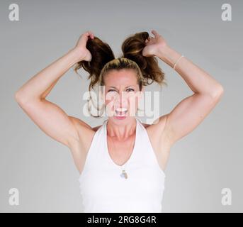 frustrierte Hausfrau / Mutter zieht an den Haaren Stockfoto