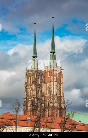 Breslau, Polen - 25 2023. März: Hohe alte zwei Türme der Kathedrale St. Johannes der Täufer mit dunklem Himmel am Nachmittag Stockfoto