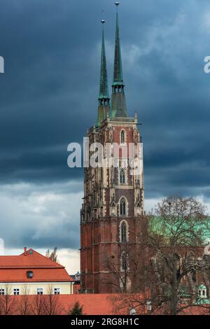 Breslau, Polen - 25 2023. März: Hohe alte zwei Türme der Kathedrale St. Johannes der Täufer mit dunklem Himmel am Nachmittag Stockfoto