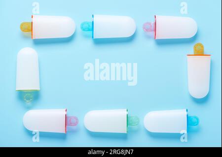 Eisformen liegen wie ein Rahmen auf der zyanblauen Oberfläche Stockfoto