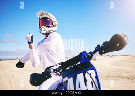 Sport, Radfahren und Menschen, die sich auf dem Motorrad auf Sand strecken, für Adrenalin, Abenteuer und Freiheit in der Wüste. Fitness, extreme Action und männliche Person Stockfoto