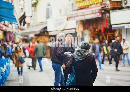 Eine nicht wiedererkennbare türkische Frau mit Kopfbedeckung, die auf einem Straßenmarkt im Uskudar-Viertel auf der asiatischen Seite von Istanbul, Türkei, einkaufen geht Stockfoto