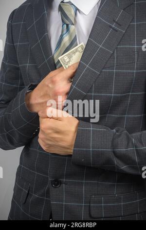 Porträt eines jungen Unternehmertums in Anzug und Krawatte mit US-Dollar Stockfoto