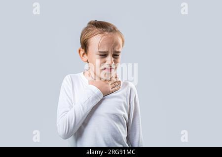 Ein kranker kleiner Junge mit Halsschmerzen. Krankes Kind mit Halsschmerzen. Halsschmerzen bei einem Kind. Das Kind hat Halsschmerzen. Erkältungszeichen bei Kindern. Kleiner Junge Stockfoto