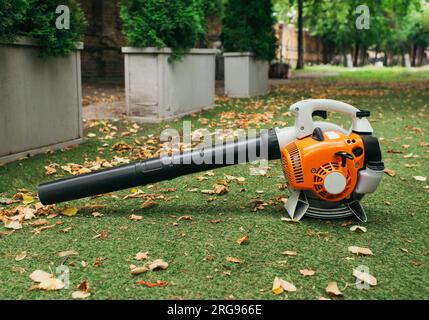 Kabellose Laubblasgeräte. Handgeführte, kabellose, elektrische Laubbläser in einem Garten, selektiver Fokus. Herbst, Herbstgärtnerei im Garten, auf dem Rasen, g Stockfoto