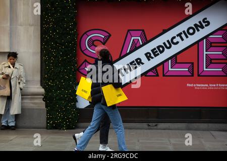 Am Neujahrstag passieren Käufer ein Verkaufsschild vor dem Selfridges Store in der Oxford Street im Zentrum von London. Stockfoto