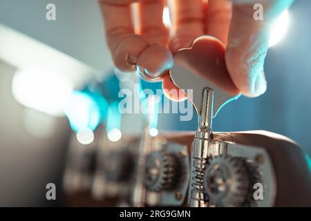Ein Musiker, der eine elektrische Bassgitarre anpasst Stockfoto