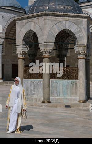 Istanbul, Türkei, Türkiye. Frau in konservativ-muslimischem Kleid mit Hijab im Hof der Blauen Moschee (Sultan-Ahmed-Moschee) Stockfoto